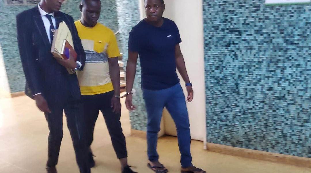 Douglas Emmanuel Jekanyika and Godknows Gunda (in yellow T-Shirt) walk with their lawyer at the Harare Magistrates Court on March 7, 2024